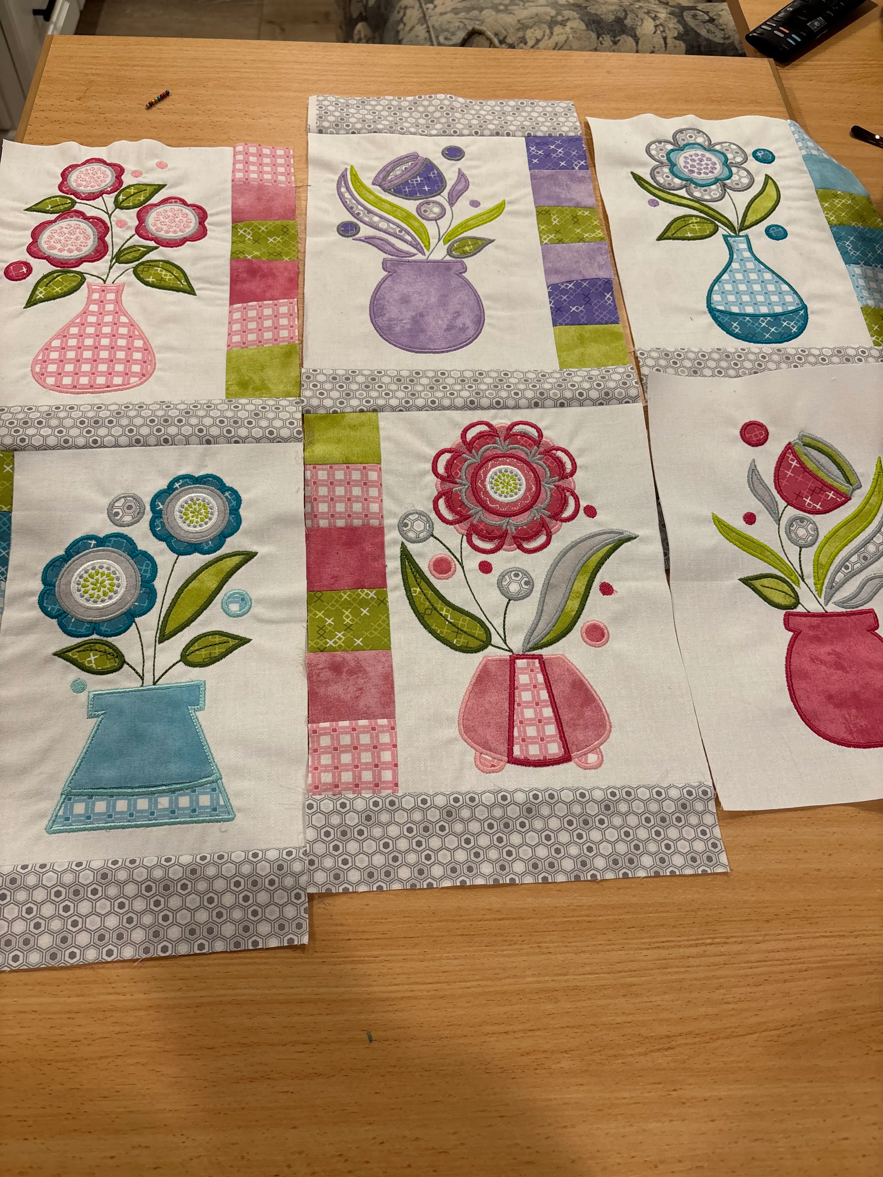 Cheerful quilted fabric panels with flower vase designs in pink, blue, and green