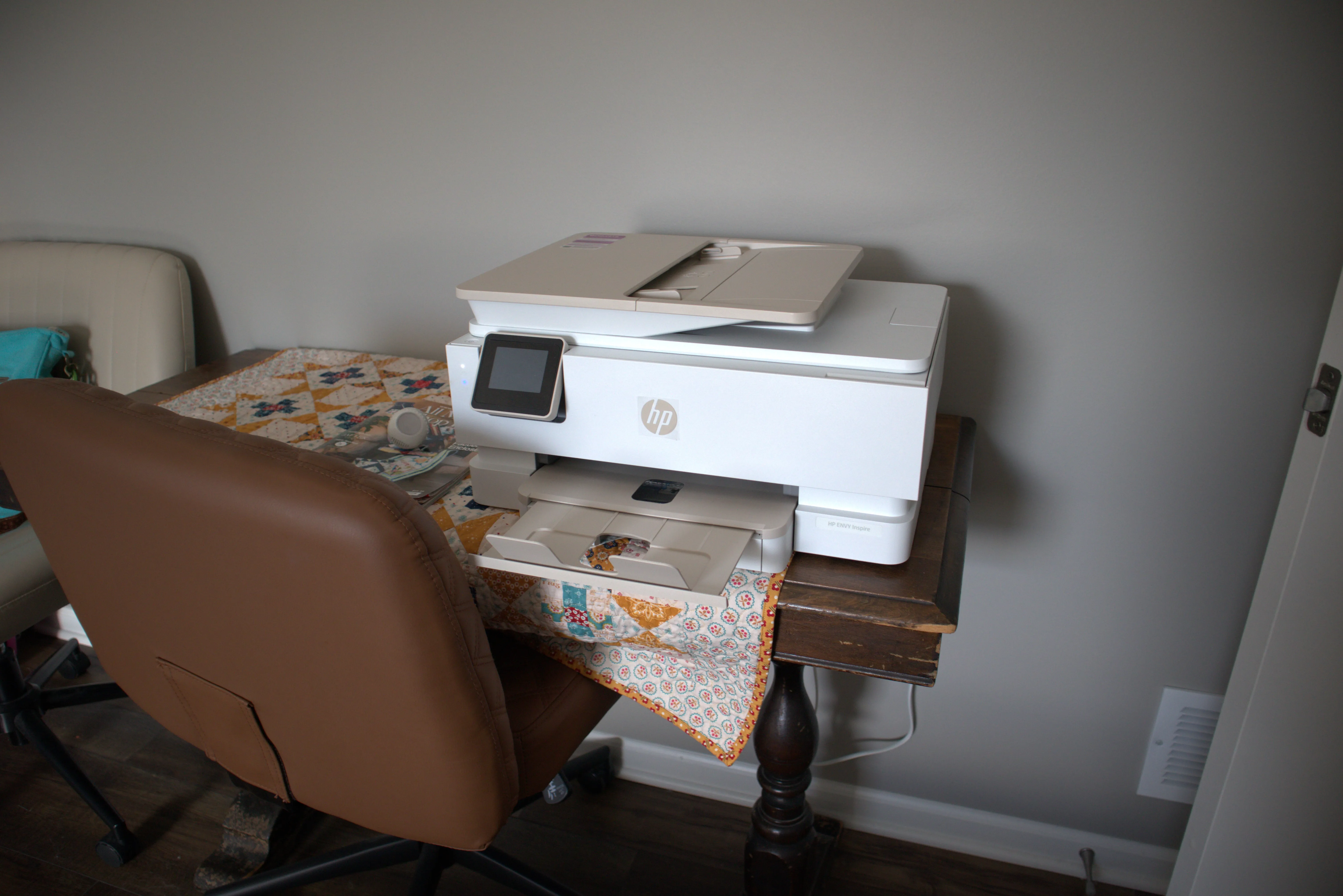 HP all-in-one printer on a vintage table with a quilted runner, ready for printing patterns