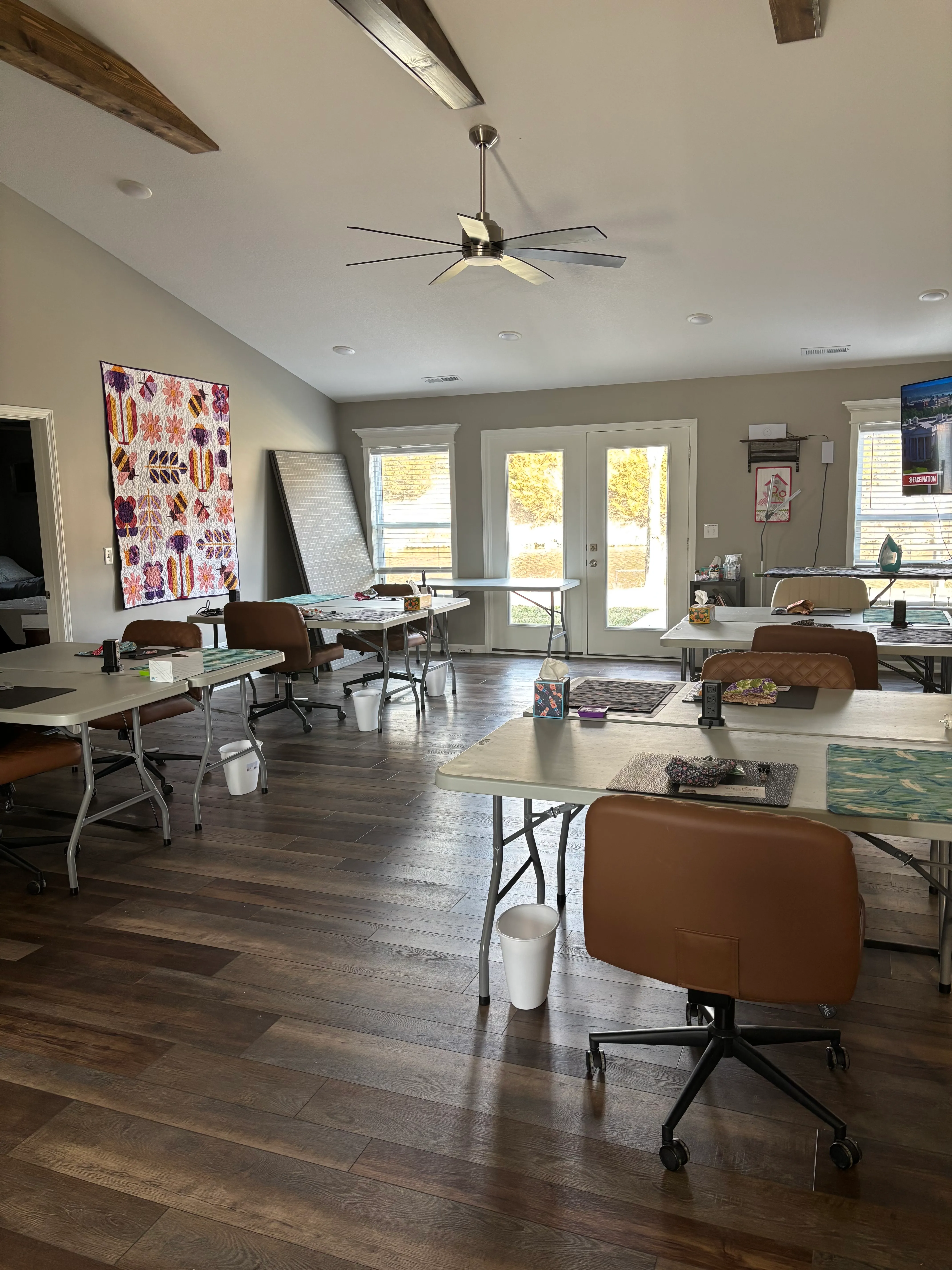 Spacious crafting area with tables, chairs, and bright windows